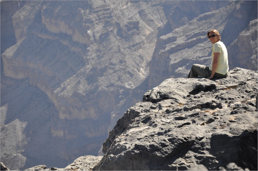 sitting at the edge of wadi ghul - oman's grand canyon